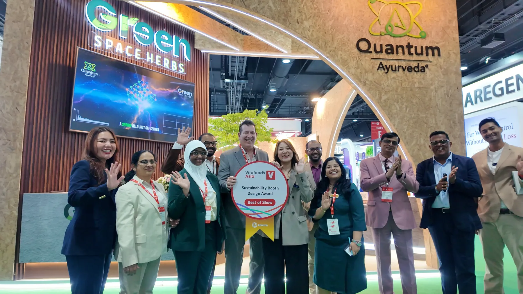 The Greenspace Herbs team celebrating with the Best of Show plaque in front of the booth
