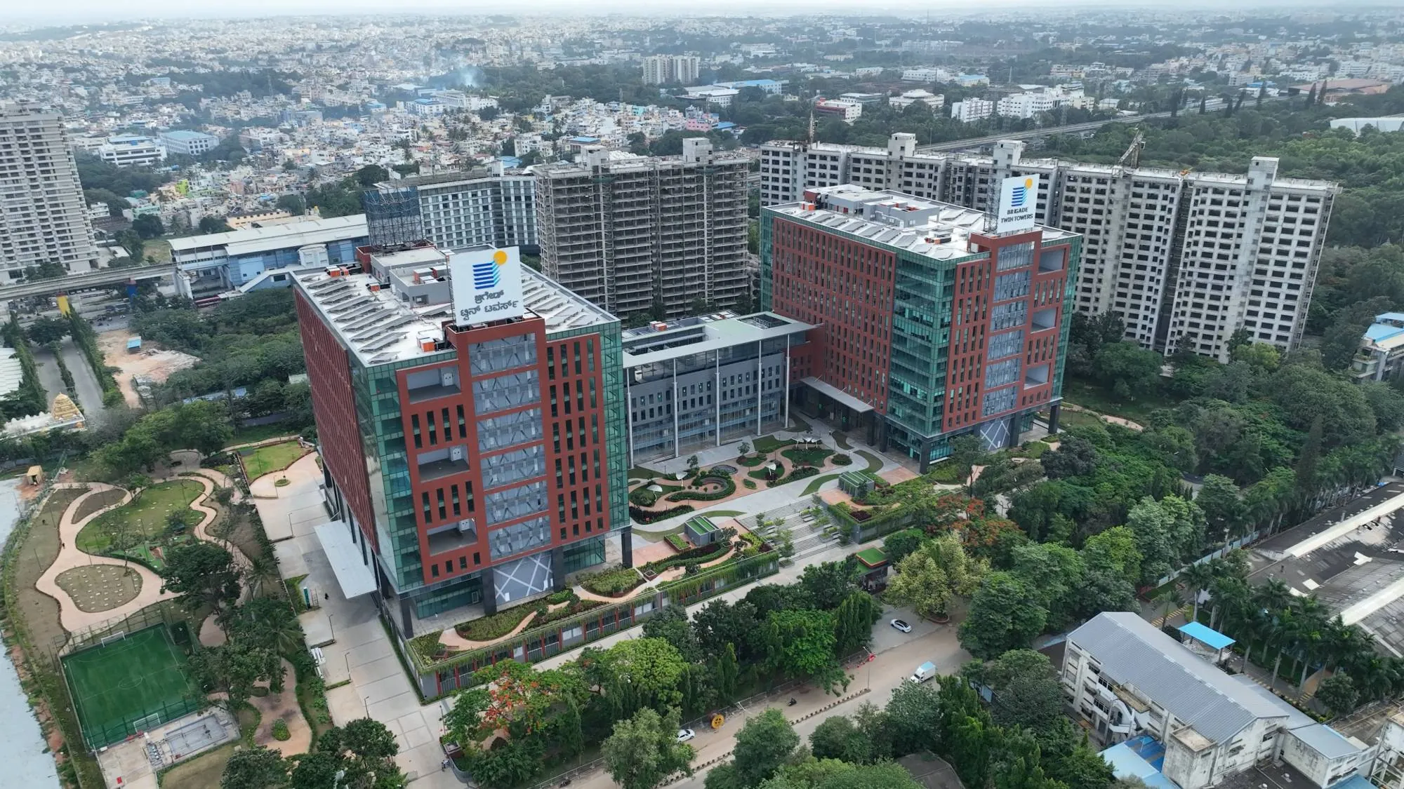 Aerial view of Brigade Twin Towers in Yeshwanthpur, Bengaluru: two red and glass office towers around a landscaped central garden