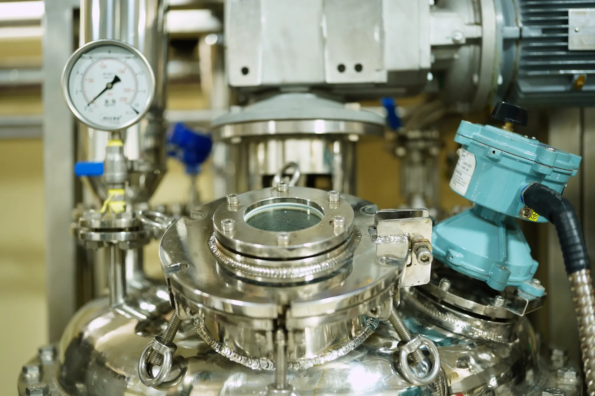 The sight glass and pressure gauge on top of a pilot plant reactor