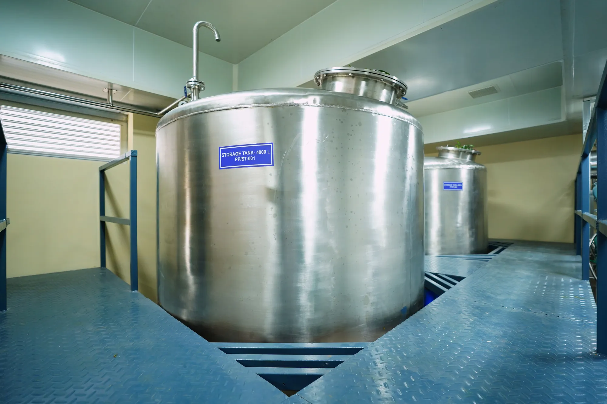 A stainless storage tank set into its platform in the pilot plant