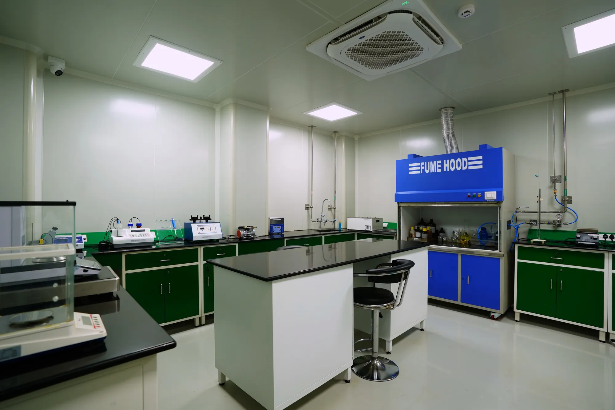 A laboratory with a fume hood, a central island and balances