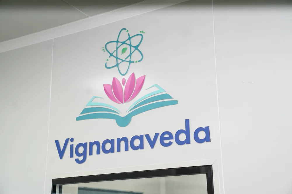 The Vignanaveda mark on the laboratory wall: an atom, a lotus and an open book