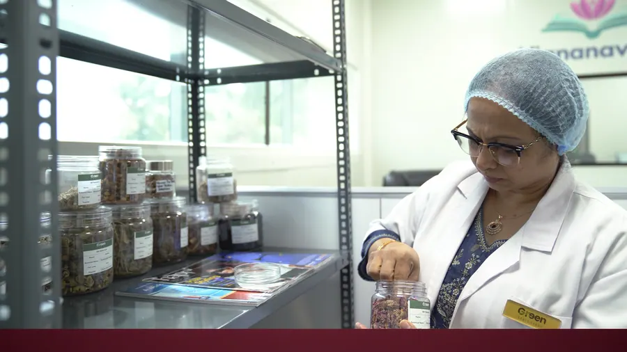 A scientist choosing a reference sample from the herbarium shelves