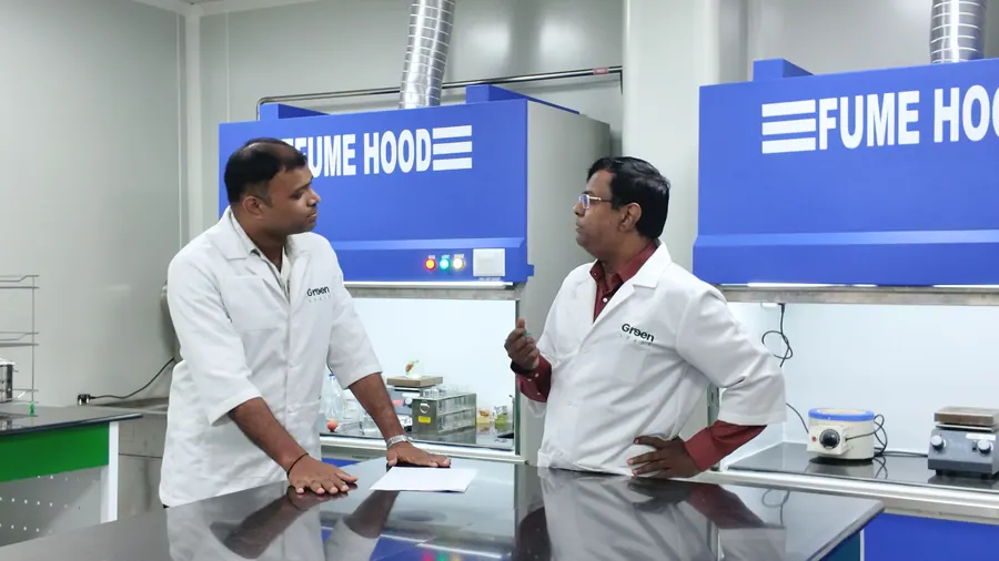 Two scientists talking at the fume hoods